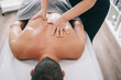 © Daniel Gonzalez/Stocksy - Doctor kneading back of patient during appointment