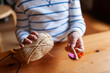 © Valentina Barreto/Stocksy - Kid making crafts at home with wool