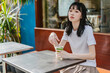 © Heng Yu/Stocksy - Girl sitting in a cafe with a drink