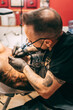 © Mal de Ojo Studio/Stocksy - Tattoo artist working at his studio