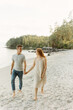 © Luke Liable/Stocksy - Young couple walking on a beach