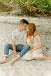 © Luke Liable/Stocksy - Young couple sitting on a beach