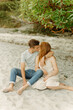 © Luke Liable/Stocksy - Young couple sitting on a beach