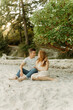 © Luke Liable/Stocksy - Young couple sitting on a beach
