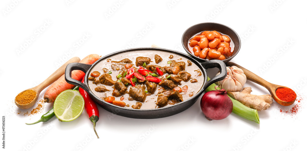 Dish with tasty beef curry and ingredients on white background