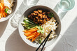 © Sophia Hsin/Stocksy - vegan black bean noodles in bowl