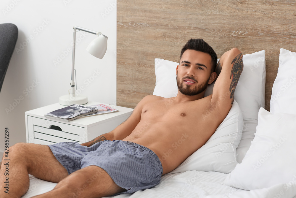 Sexy young man in underwear lying on bed