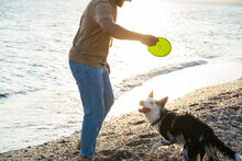 Man Playing With Dog With Frisbee