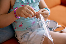 Girl Playing With White Beads