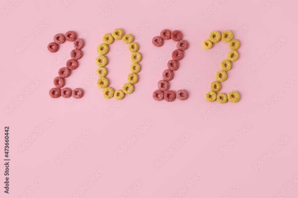 Figure 2022 made of cereal rings on pink background