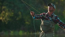 Fly Fishing. Man Fly Fishing On The Wild River With Lots Of Insects Flying In The Air