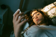 © Eloisa Ramos/Stocksy - Teen girl with her smartphone on the bed