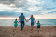 © aaalll3110 - vacation at sea. A family walks along the beach. family holding hands