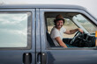 © Malquerida Studio/Stocksy - Smiling man drives a camper van
