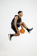 © Javier Díez/Stocksy - Black basketball player jumping with ball
