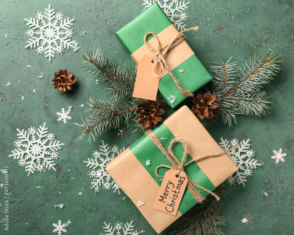 Beautiful snowflakes, fir branches and gift boxes on green background