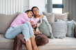 © Bisual Studio/Stocksy - Happy siblings chilling on sofa