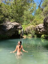Woman Bathing In A Natural Pool In The Mountains