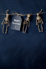 A Note With Tiny Skeletons Hanging With String 