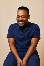 Young African American Male Nurse In Blue Scrubs Laughing 