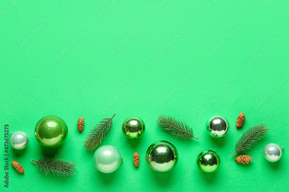 Composition with Christmas balls, cones and fir branches on green background