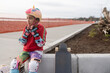 © Jennifer Bogle/Stocksy - Skateboarding girl fastens helmet