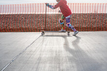 Girl Skateboarding By Safety Fence