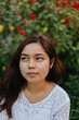 © Tripty Tamang Pakhrin/Stocksy - Young south asian woman among red flowers
