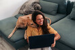 © Lucas Ottone/Stocksy - Woman working from home with her dog