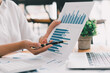 © PaeGAG - Business people working with graphs, business documents on their desks to analyze for business startups.