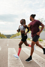 Athletic Black Runners Crossing Road
