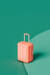 © Giada Canu/Stocksy - pink Suitcase on a green background. travel concept.