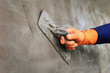 Plastering concrete to create industrial worker wall background with plastering tools