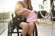 © Santi Nuñez/Stocksy - Unrecognizable mom in wheelchair with her daughter