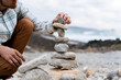 © Alba Vitta/Stocksy - Man doing Zen balanced stones stack on beach