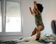 © Jelena Markovic/Stocksy - Toddler jumping on the bed