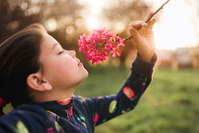 Young Girl Smelling Cherry Flowers