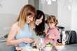 © Albert Martinez/Stocksy - lesbian couple cooking healthy food with their daughter