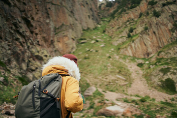 Wall Mural - woman in yellow jacket hiking in the mountains travel adventure