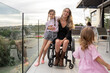 © Santi Nuñez/Stocksy - Portrait of mother in wheelchair with her daughters