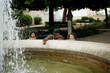 © Jelena Markovic/Stocksy - Young father playing with kids by fountain