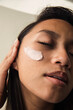 © Anna Tabakova/Stocksy - Beautiful filipino model applying skincare