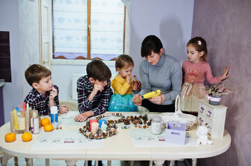 Mother with four kids makes a wreath for Christmas Eve and crafting decorating. New Year celebration.