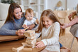 © Tatiana Timofeeva/Stocksy - family plays jenga at home