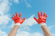 © Jeongho Byeon/Stocksy - Red work gloves and sky