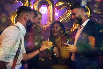 Happy group of friends celebrate New Year's Eve and exchanging gifts