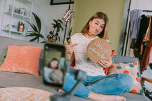 Teenage Girl Showing Like And Subscribe Sign While Filming At Home