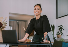 Businesswoman Leaning At Desk In Office