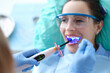 © H_Ko - Dentist works with dental polymerization lamp in oral cavity