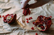 © Natalia Mishina/Stocksy - Pomegranate seeds in the hands.